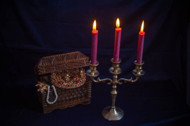 Mum ışığında hazine, eski ahşap bir kutuda masanın üstünde.