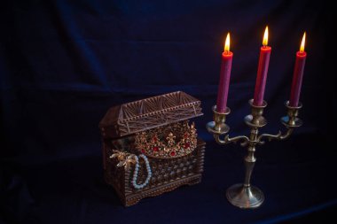 Mum ışığında hazine, eski ahşap bir kutuda masanın üstünde.