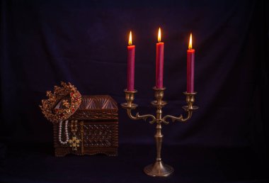 Mum ışığında hazine, eski ahşap bir kutuda masanın üstünde.