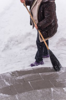 Kışın kar yağarken süpürgeyle derin kar temizliyorum. Kar yağışı, soğuk hava ve mevsimsel zorluklar kavramı