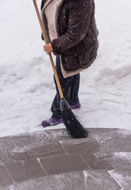 Kışın kar yağarken süpürgeyle derin kar temizliyorum. Kar yağışı, soğuk hava ve mevsimsel zorluklar kavramı