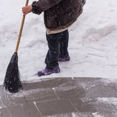 Kışın kar yağarken süpürgeyle derin kar temizliyorum. Kar yağışı, soğuk hava ve mevsimsel zorluklar kavramı