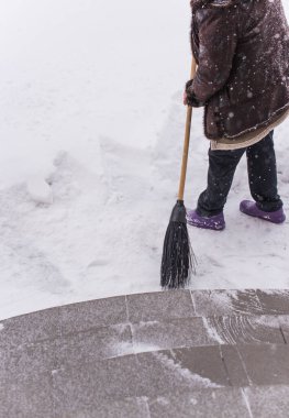 Kışın kar yağarken süpürgeyle derin kar temizliyorum. Kar yağışı, soğuk hava ve mevsimsel zorluklar kavramı