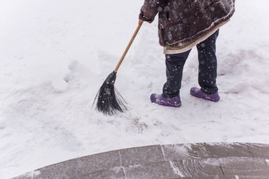 Kışın kar yağarken süpürgeyle derin kar temizliyorum. Kar yağışı, soğuk hava ve mevsimsel zorluklar kavramı