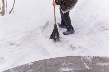 Kışın kar yağarken süpürgeyle derin kar temizliyorum. Kar yağışı, soğuk hava ve mevsimsel zorluklar kavramı