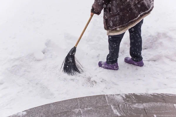 Kışın kar yağarken süpürgeyle derin kar temizliyorum. Kar yağışı, soğuk hava ve mevsimsel zorluklar kavramı