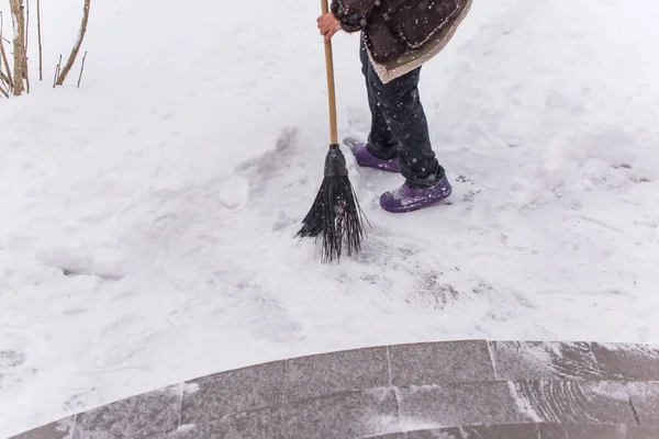 Kışın kar yağarken süpürgeyle derin kar temizliyorum. Kar yağışı, soğuk hava ve mevsimsel zorluklar kavramı