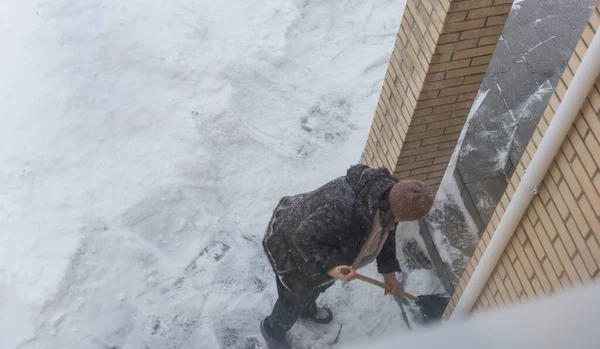 Kışın kar yağarken süpürgeyle derin kar temizliyorum. Kar yağışı, soğuk hava ve mevsimsel zorluklar kavramı