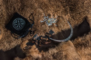 İskandinav tahta mührü, antik İskandinav kehanetinin, mistisizminin ve ruhani ritüellerin sembolü olarak bir masaya dizilmiştir.