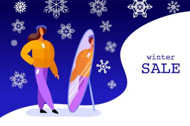 Kadın elbiseleri deniyor. Kış alışverişi. Bir kız aynaya bakar. Satılık kış arkaplanı