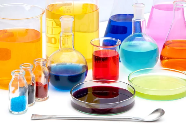 化学実験室で様々な色の液体を持つ研究室用ガラス製品 白い背景にボリュームのある研究室用ガラス製品 — ストック写真
