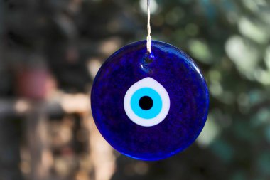 Kem göz boncuğu, Türk nazar boncuğu. Mavi nazar boncukları bir ağaç dalından sarkan bir iple sallanıyor. Geleneksel Uğursuz Göz Madalyonları