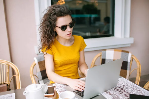 Jovem menina beautidul com laptop e chá no café ao ar livre — Fotografia de Stock