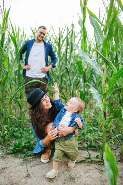 Joven familia hipster con lindo bebé en maizal sonriendo — Foto de Stock