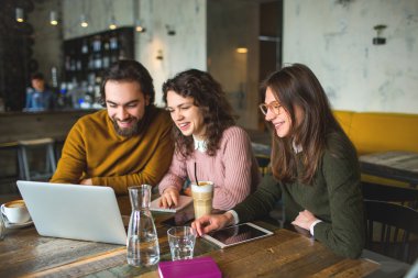 Yong hippi erkek ve dişiler kafede dizüstü bilgisayar ile çalışma