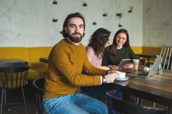 Yong hipster hombre y mujeres en la cafetería trabajando con el ordenador portátil — Foto de Stock