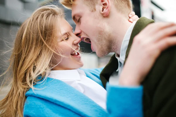 Jonge gelukkige blonde paar zoenen en knuffelen op stad straat — Stockfoto