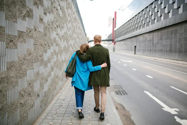 Joven feliz pareja caminando calle de la ciudad tomados de la mano en el amor — Foto de Stock