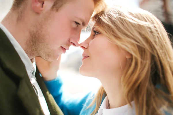 Young happy blonde couple kissing and hugging on city street — Stok fotoğraf