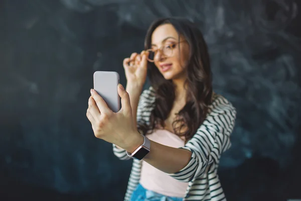 Joven mujer bonita con teléfono inteligente en su mano tomando fotos — Foto de Stock