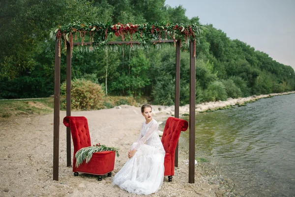 Bella donna in abito da sposa in riva al mare — Foto Stock