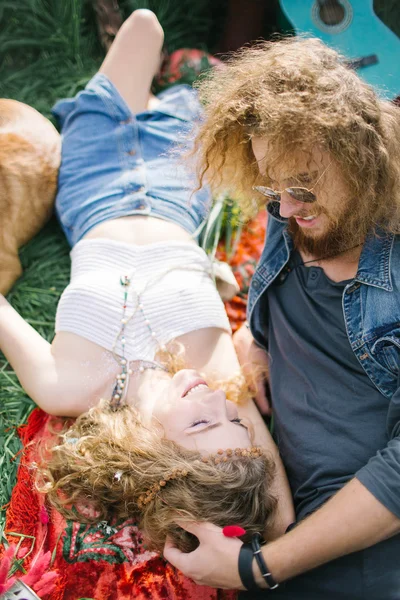 Young beautiful hippie couple lying on grass having fun — Stock Photo, Image