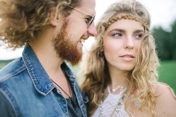 Young hippie male with beard hugging curly female outdoors — Stock Photo, Image