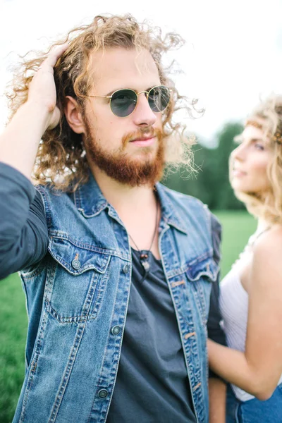 Young hippie male with beard hugging curly female outdoors — Stock Photo, Image