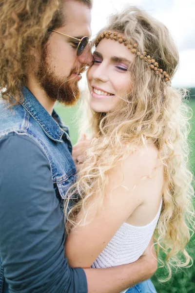Jovem hippie masculino com barba abraçando encaracolado feminino ao ar livre — Fotografia de Stock