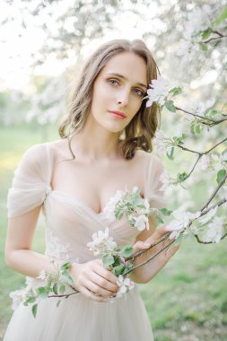 Genç güzel gelin portre çiçeklerle parkta