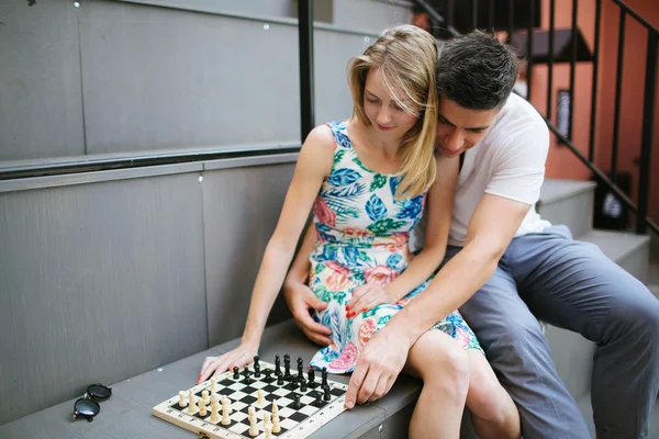 Jovem casal bonito jogando xadrez ao ar livre na cidade — Fotografia de Stock