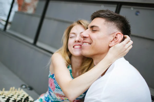 Jovem casal bonito jogando xadrez ao ar livre na cidade — Fotografia de Stock