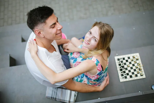 Jovem casal bonito jogando xadrez ao ar livre na cidade — Fotografia de Stock