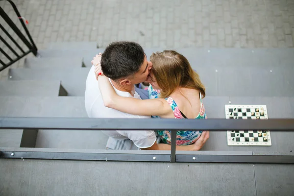 Jovem casal bonito jogando xadrez ao ar livre na cidade — Fotografia de Stock