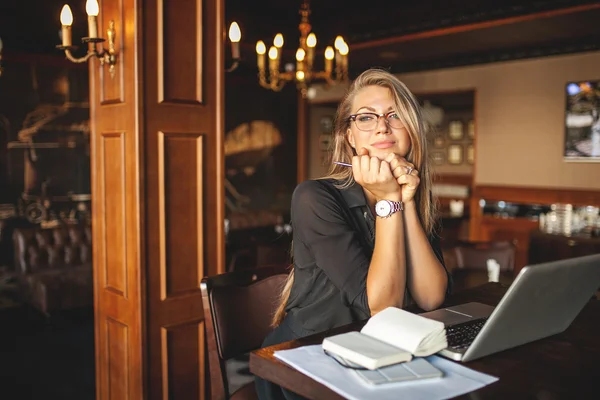 Mulher no café com laptop tomando notas — Fotografia de Stock