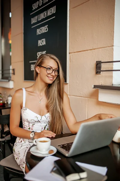 Mujer en la cafetería con portátil tomando notas — Foto de Stock