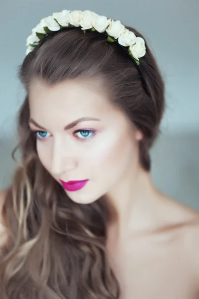 Portrait of beautiful woman with flowers in hair and blue eyes — Stock Photo, Image