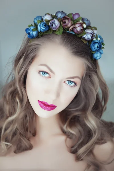 Porträt einer schönen Frau mit Blumen im Haar und blauen Augen — Stockfoto