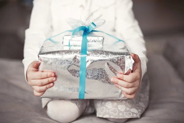 Bebé sostiene una caja de regalo de Navidad en las manos — Foto de Stock