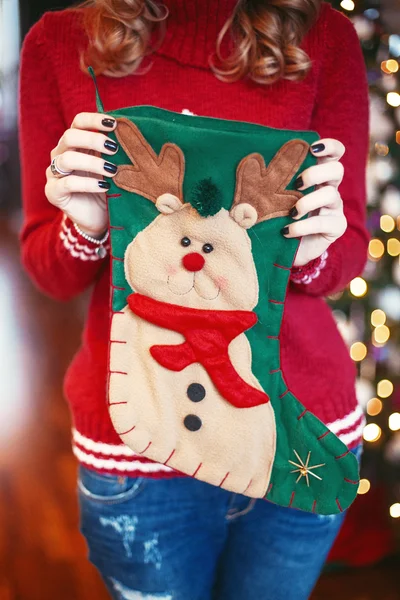 Mujer sostiene un calcetines de Navidad con regalos — Foto de Stock