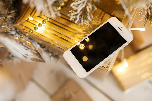 Białe smartphone z choinki w tle — Zdjęcie stockowe