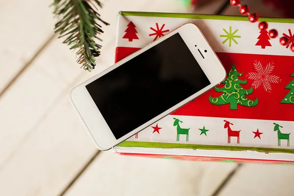 Beyaz smartphone ile arka planda Noel ağacı