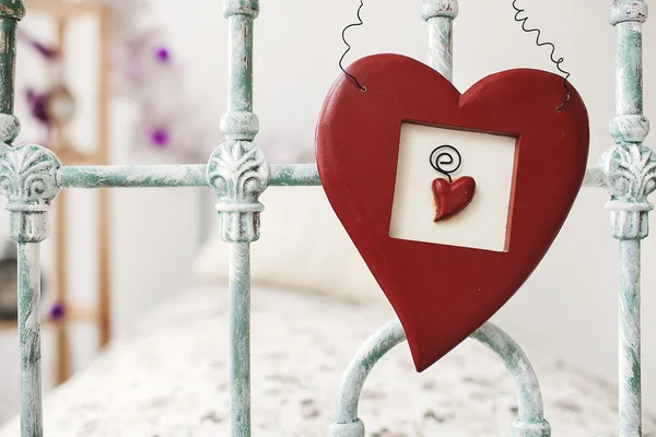 De dag van Valentijnskaarten speelgoed hart opknoping boven retro bed op achtergrond wi — Stockfoto
