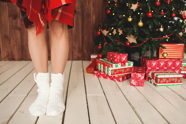 Mujer de pie en calcetines en el árbol de Navidad decorado —  Fotos de Stock