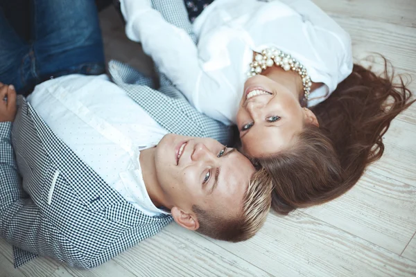 Jeune couple couché sur le sol en bois — Photo