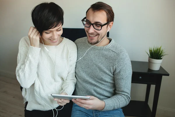 Hipster pareja disfrutando de vídeo musical en la tableta juntos — Foto de Stock