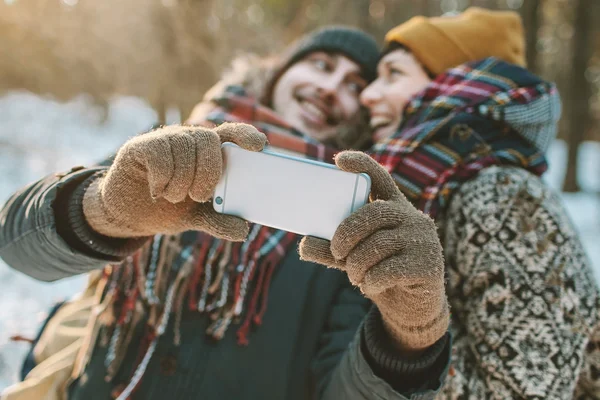 Casal fazendo selfie na floresta de inverno — Fotografia de Stock