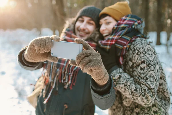 Casal fazendo selfie na floresta de inverno — Fotografia de Stock