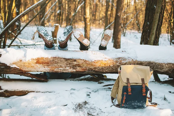 Couple étendu sur le sol dans la forêt d'hiver avec les jambes sur la tr — Photo