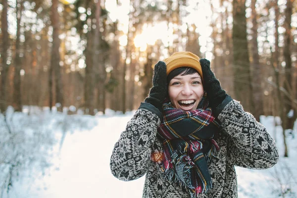 Mujer joven sonríe en el bosque de invierno — Foto de Stock